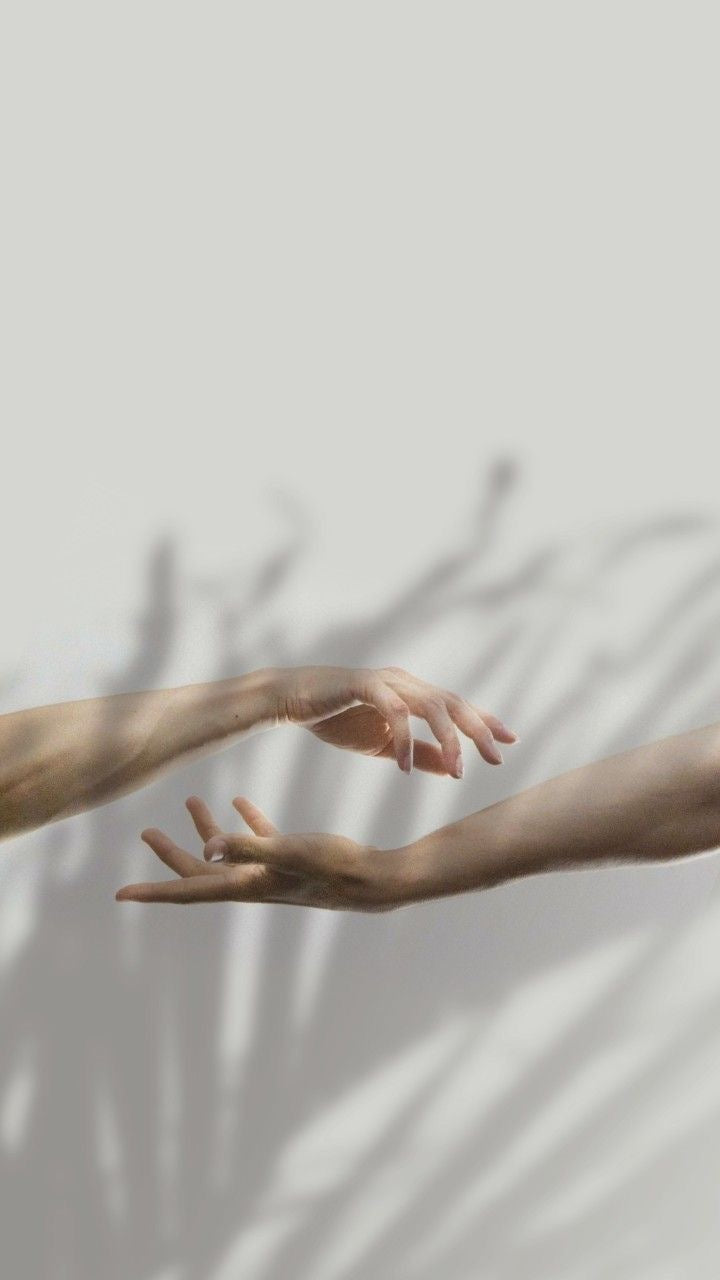 two hands with shadows on white wall