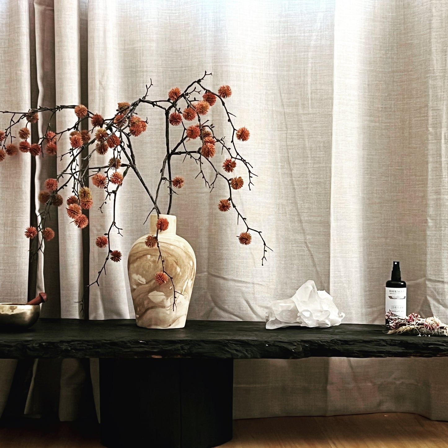 Shemana mist with dried orange flowers and black table